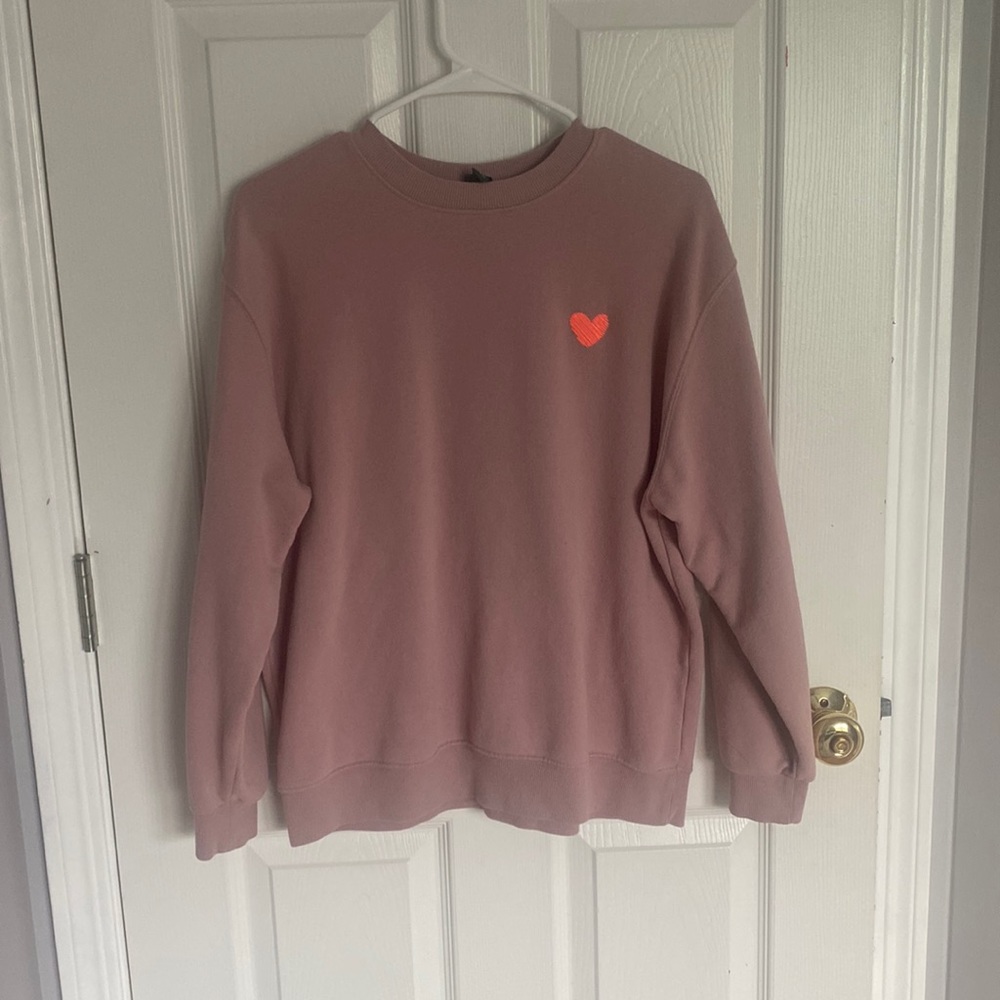 Pink crewneck with orange heart.